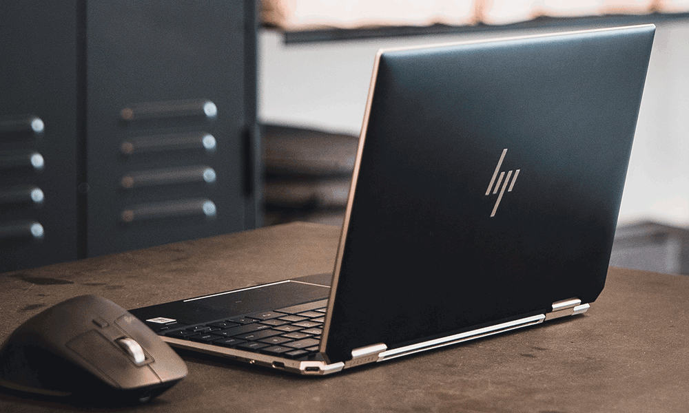 laptop-hp Ein HP-Laptop steht auf einem Schreibtisch, daneben eine Maus.